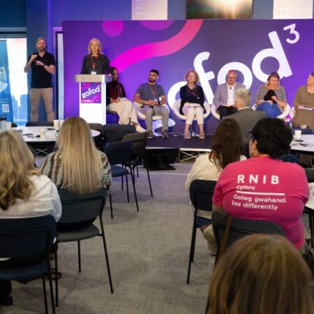 Audience watching a panel discussion on stage with “gofod3” branding in the background.